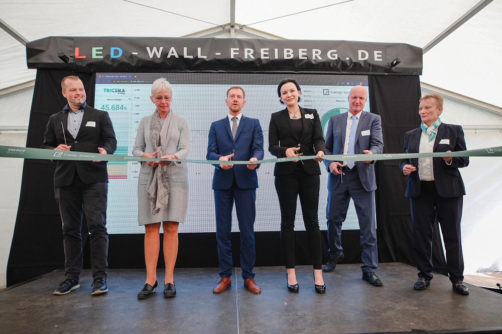 Foto zeigt symbolisches Durchschneiden des Bands bei Pressetermin zur Eröffnung von Sachsens größtem Speicher bei JT Energy in Freiberg