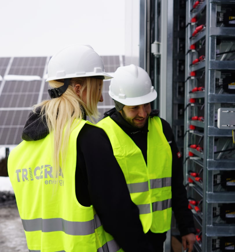 Two employees look inside a container Two employees wearing yellow high-visibility vests look inside a container with racks and storage modules.